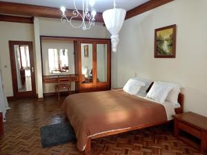 a bedroom with a large bed and a chandelier at La Résidence d'Ankerana in Antananarivo