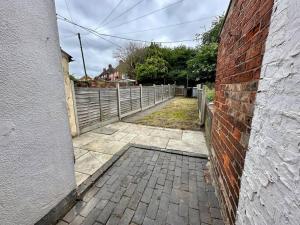 a brick alley with a fence in a house at EasyRest House 3 Grantham - 5 Beds & Free Parking - Easy Location - Access to A1, Town Centre & Shops in Grantham