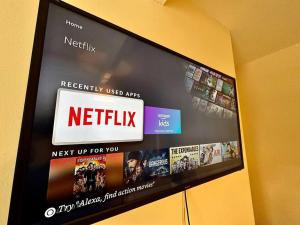 a television screen with a netflix sign on a wall at EasyRest House 3 Grantham - 5 Beds & Free Parking - Easy Location - Access to A1, Town Centre & Shops in Grantham