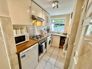 a kitchen with a stove and a microwave at EasyRest House 3 Grantham - 5 Beds & Free Parking - Easy Location - Access to A1, Town Centre & Shops in Grantham