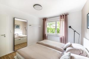 a white room with a mirror and a bed at City-Luxus Apartment Rottweil in Rottweil