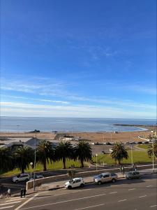 een straat met auto's geparkeerd op een weg naast het strand bij ALMAR III Sólo para familias in Mar del Plata