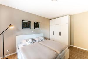 a bedroom with a bed and a white cabinet at City-Luxus Apartment Rottweil in Rottweil