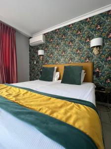 a bedroom with a large bed with a yellow blanket at B&B HOTEL Perpignan Centre in Perpignan