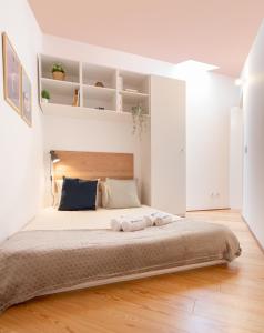 ポルトにあるHost Wise - Quiet Colourful House - Gardenの白い壁の大きなベッドのある寝室