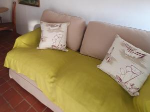a couch with a yellow blanket and two pillows on it at Ocean Walk Manta in Zinkwazi Beach