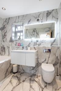 ein Badezimmer mit einem Waschbecken, einem WC und einem Spiegel in der Unterkunft Home in Saltford with Hot Tub and Sauna. in Saltford