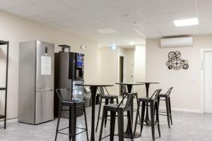 una stanza con tavoli, sedie e frigorifero di Piccolo Catalunya Hostel ad Alghero