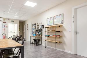 a room with a table and chairs and a shelf at Piccolo Catalunya Hostel in Alghero