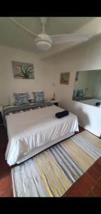 a bedroom with a large white bed and a rug at Ocean Walk Manta in Zinkwazi Beach