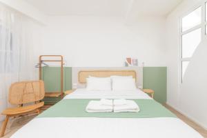 1 dormitorio con 1 cama con 2 toallas en Evergreen apartment by Beginning with, 3BR in heart of Nimman, en Chiang Mai