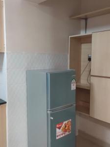 a blue refrigerator in a room with a kitchen at Zerra Luxury 3 bedroom in Nakuru CBD in Nakuru