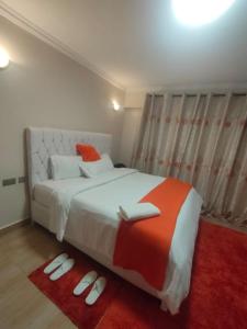 a bedroom with a large bed with a red rug at Zerra Luxury 3 bedroom in Nakuru CBD in Nakuru