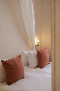 a white bed with two pillows and a cross on top at L'Abbaye Hôtel in La Colle-sur-Loup