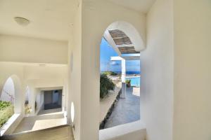 a view of the ocean from the hallway of a house at Cossyra Hotel in Pantelleria