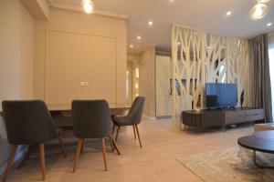 a living room with a table and chairs and a tv at Luxury Residence Mamaia in Mamaia