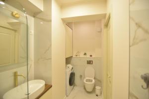 a white bathroom with a toilet and a sink at Luxury Residence Mamaia in Mamaia +35 photos