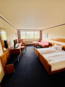 ein Hotelzimmer mit einem Bett und einem Schreibtisch in der Unterkunft Hotel Sonnenberg Garni in Hinterzarten