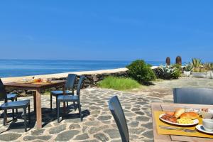 a table with a plate of food on the beach at Cossyra Hotel in Pantelleria