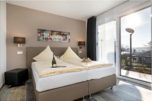 een groot bed in een kamer met een groot raam bij Villa Nova by Callsen in Binz
