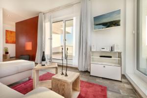 een woonkamer met een witte bank en een rood tapijt bij Villa Nova by Callsen in Binz