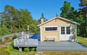 a tiny house with a porch and a bench on a deck at Stunning Home In Brekkest With Kitchen 