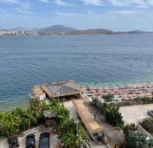an aerial view of a beach with umbrellas and the ocean at Port Side Sarande in Sarandë