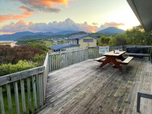 a wooden deck with a picnic table on it at Aqua Views - Kuratau Holiday Home in Kuratau