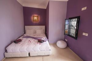 a bedroom with a white bed with purple walls at Riad RIM in Marrakesh
