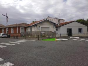 ein leerer Parkplatz mit einem Gebäude mit grünem Feld in der Unterkunft Le petit paradis iodé in Gujan-Mestras