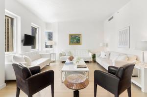 a living room with white furniture and a table at Luxury Midtown West 4 Bedroom Apartment Near Radio City in New York