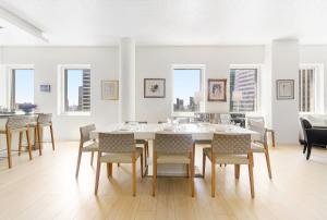 a white dining room with a table and chairs at Luxury Midtown West 4 Bedroom Apartment Near Radio City in New York