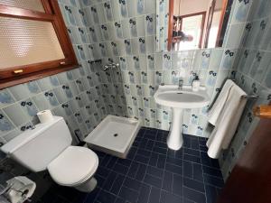 La salle de bains bleue et blanche est pourvue d'un lavabo et de toilettes. dans l'établissement El Llobarret de Baix a Mar, à Torredembarra 8 autres photos