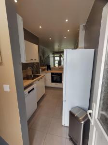uma cozinha com electrodomésticos brancos e um frigorífico branco em Maison Malo-Lina à 350m de la plage de Malo les bains em Dunkerque