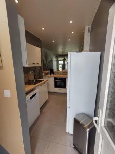 una cucina con elettrodomestici bianchi e frigorifero bianco di Maison Malo-Lina à 350m de la plage de Malo les bains a Dunkerque