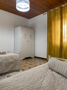 1 dormitorio con 2 camas y cortina amarilla en Appartamento Vacanze Dommu Mia, en Arzana