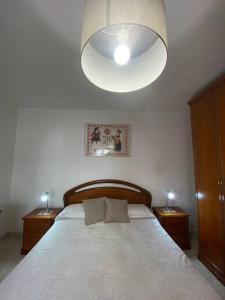 1 dormitorio con 1 cama blanca grande y 2 mesitas de noche en Appartamento Vacanze Dommu Mia, en Arzana