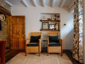 zwei Korbstühle in einem Wohnzimmer in der Unterkunft Armada Cottage in Charlbury