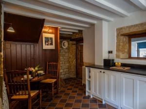 a kitchen with a table and a dining room at Armada Cottage in Charlbury