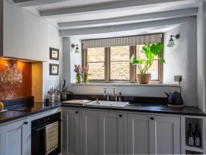 a kitchen with a sink and a window at Armada Cottage in Charlbury