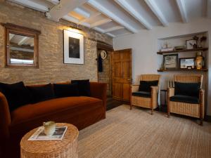 ein Wohnzimmer mit einer Couch und zwei Sesseln in der Unterkunft Armada Cottage in Charlbury