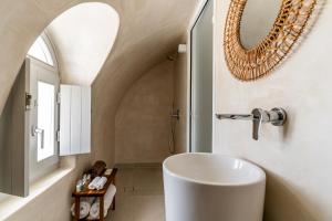 Un baño con un lavabo blanco y un espejo. en Arotron Santorini, en Pirgos