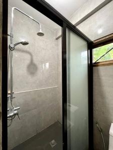 a shower in a bathroom with a glass door at Marhay Villa Siargao in General Luna