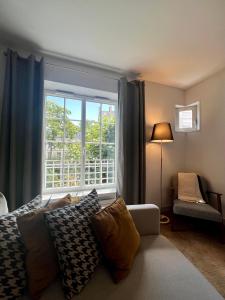ein Wohnzimmer mit einem großen Fenster und einem Sofa in der Unterkunft Spacious & modern flat close to Parc Monceau in Paris