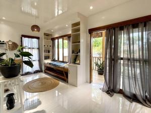 a large living room with a fireplace and windows at Marhay Villa Siargao in General Luna