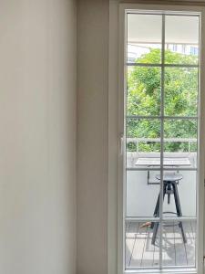 eine Tür zu einem Balkon mit einem Tisch und einem Fenster in der Unterkunft Spacious & modern flat close to Parc Monceau in Paris