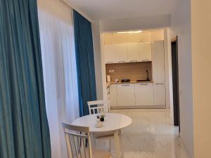 a white table and chairs in a room with a kitchen at Savoy Mamaia Studio in Mamaia