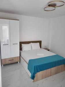 a bedroom with a bed with a blue blanket at Savoy Mamaia Studio in Mamaia