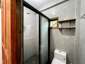 a bathroom with a toilet and a glass shower at Marhay Villa Siargao in General Luna