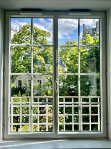 ein offenes Fenster mit Blick auf ein Haus in der Unterkunft Spacious & modern flat close to Parc Monceau in Paris